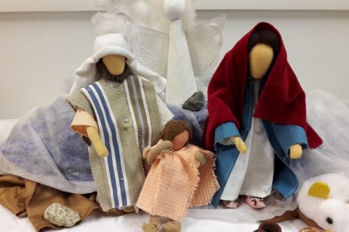 Maria, Joosef ja Jeesus-lapsi -nuket lähikuvassa heidän takanaan valkoinen enkelinukke.